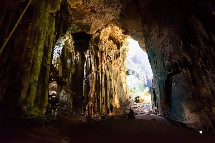 Una amplia vista del interior de una enorme cueva con personas en una pasarela de madera.